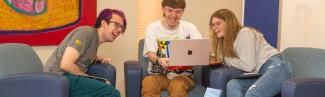 三名全球网络赌博平台的学生围坐在一台笔记本电脑前
